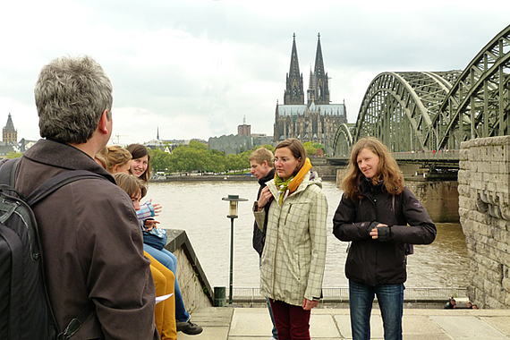Foto: Teilnehmende stehen am Rheinufer von Köln.