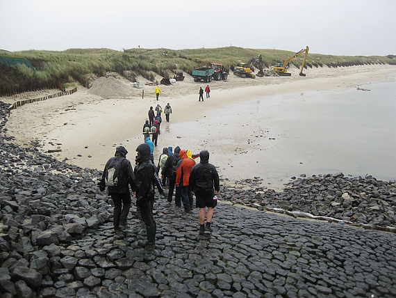 Foto: Studierende laufen zu einem Strand runter.
