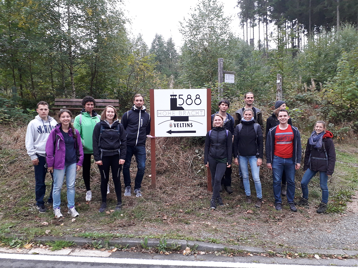 Photo: Excursion participants stand in front of a sign pointing to Hohen Bracht.